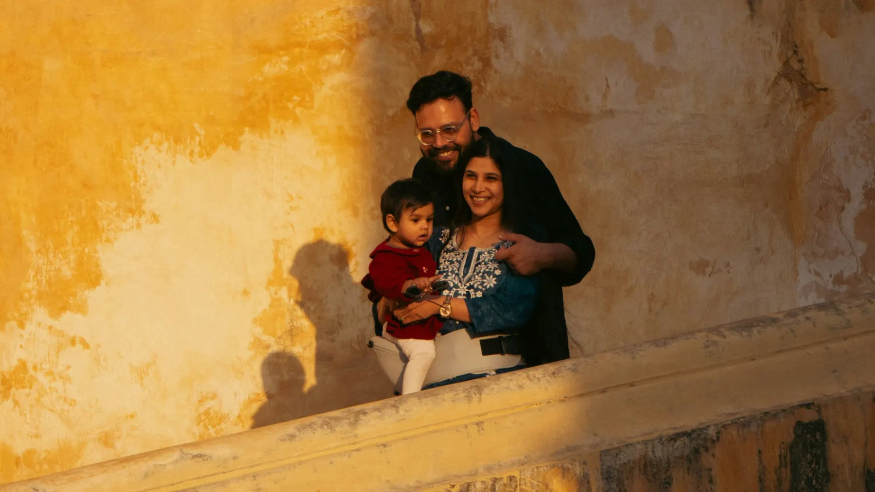 Familia sonriendo junto a un muro dorado